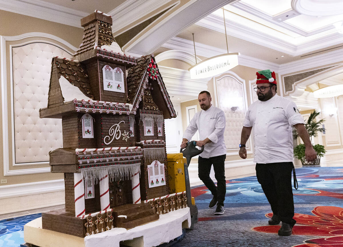 Philippe Angibeau, executive pastry chef at Bellagio, wheels the gingerbread house through the ...