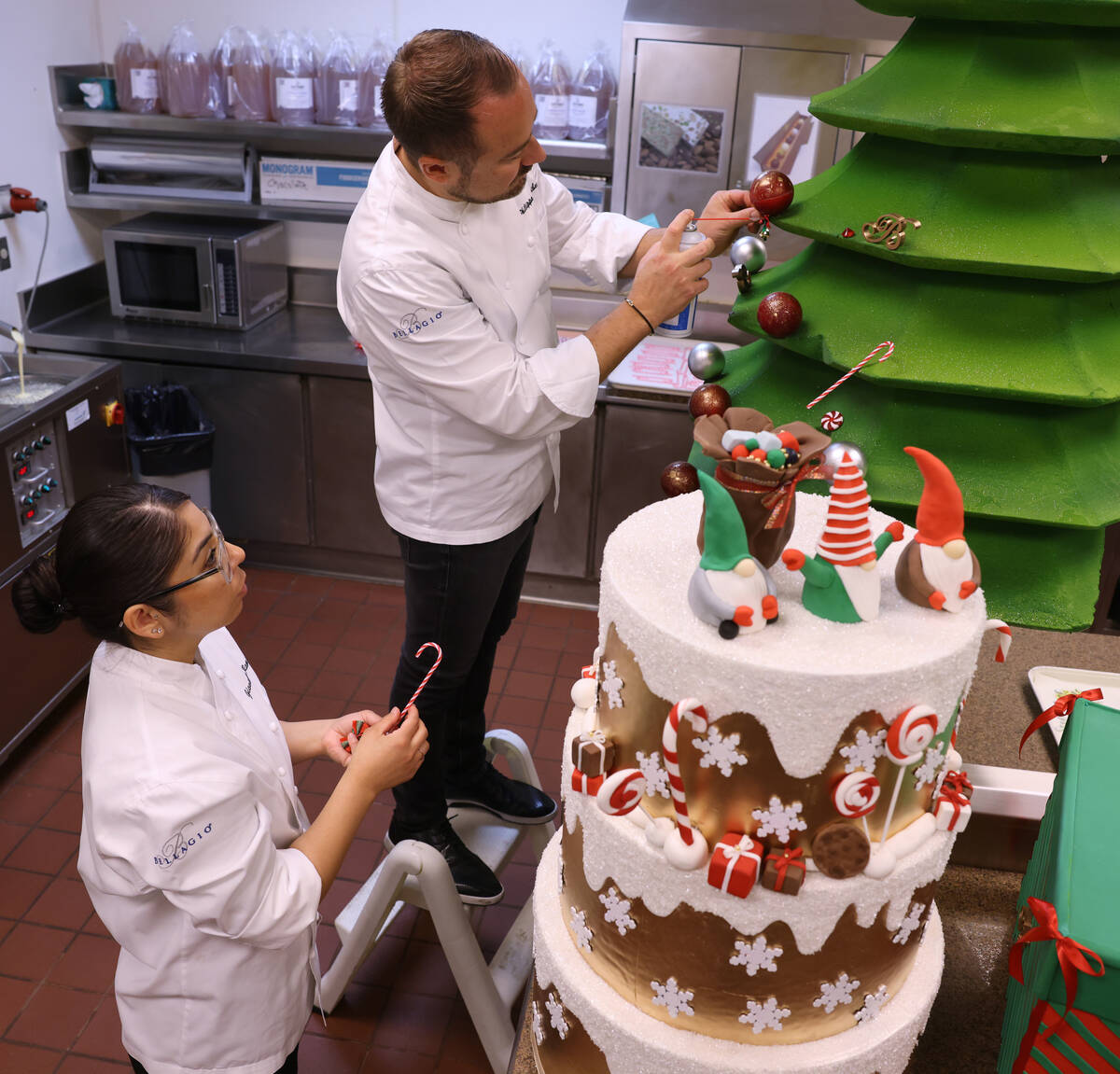 Chef director Philippe Angibeau works on a gingerbread house display with sous chef chocolatier ...