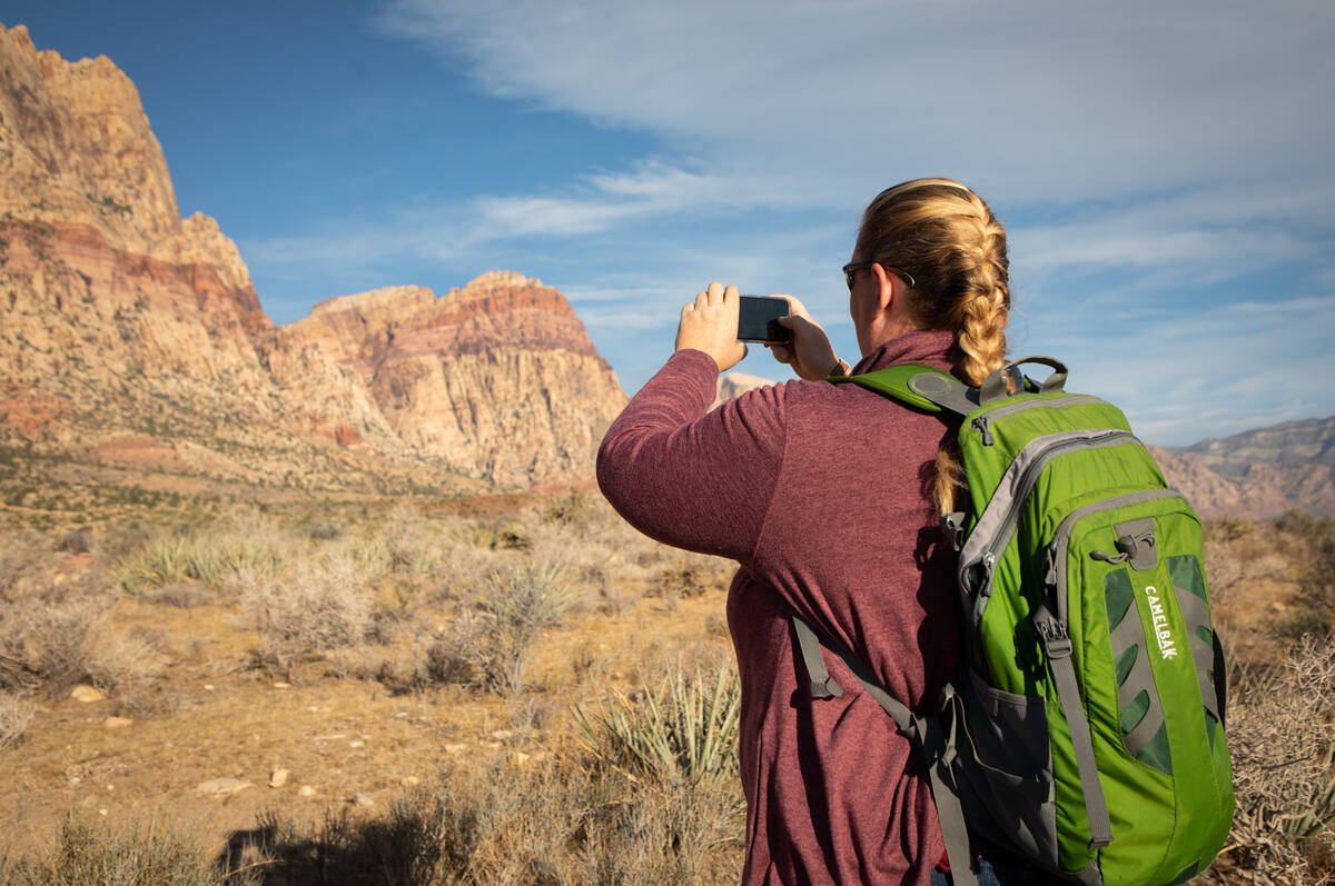 Sarah Alderks, 43, takes a photo of the scenery during an early morning hike on the First Creek ...
