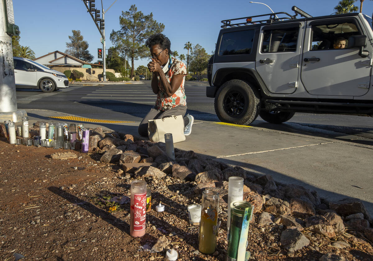 Renee Jimenez prays after lighting a candle at a roadside memorial for Tina Tintor near the acc ...