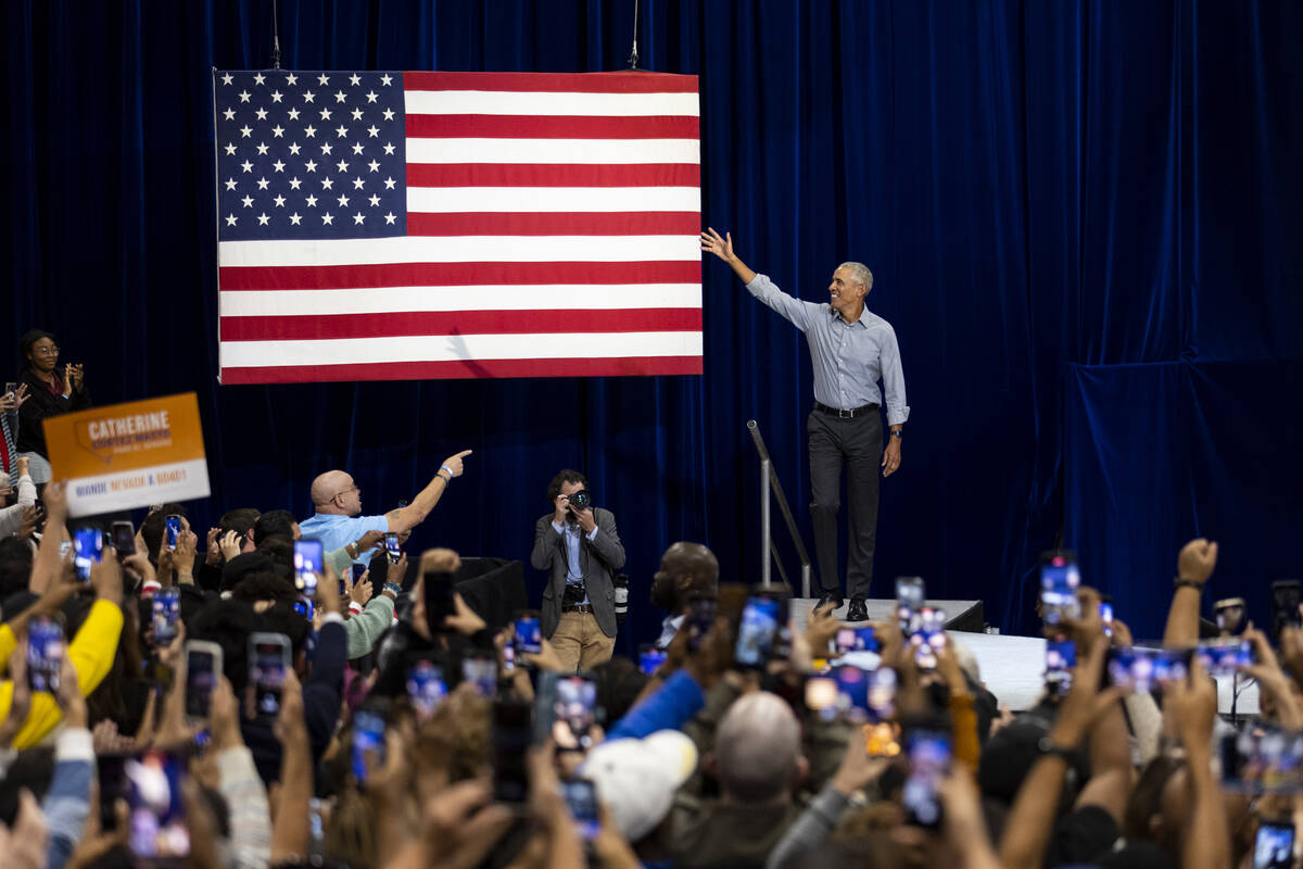 Former President Barack Obama, center, takes the stage during a campaign rally organized by Nev ...