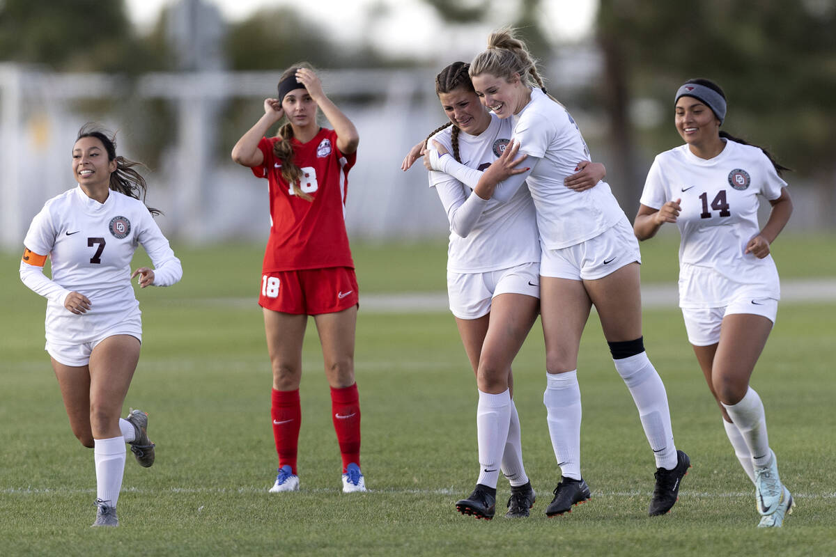 Desert Oasis’ Kate Perkes, third from left, and Taylor Wehrer, second from left, embrace ...