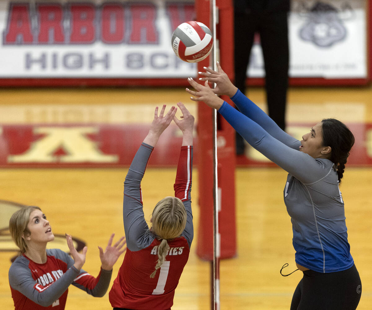 Basic’s Taylah Paepule (14) tips the ball over the net while Arbor View’s Evelyn ...