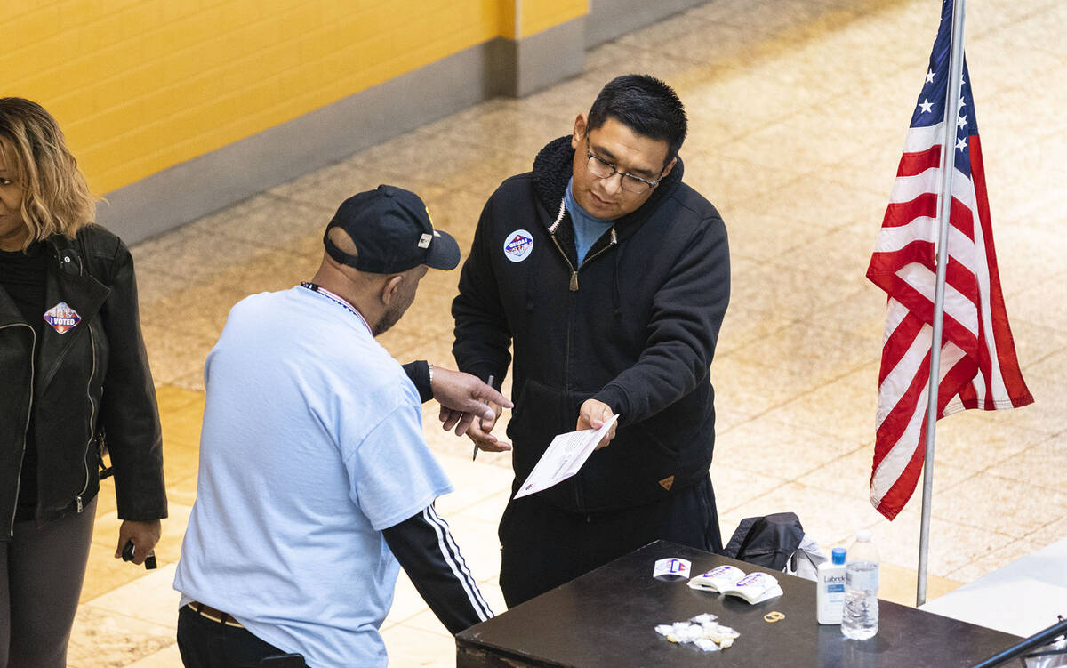 A Voter, who declined to give his name, prepares to place his ballot in an official mail-in bal ...