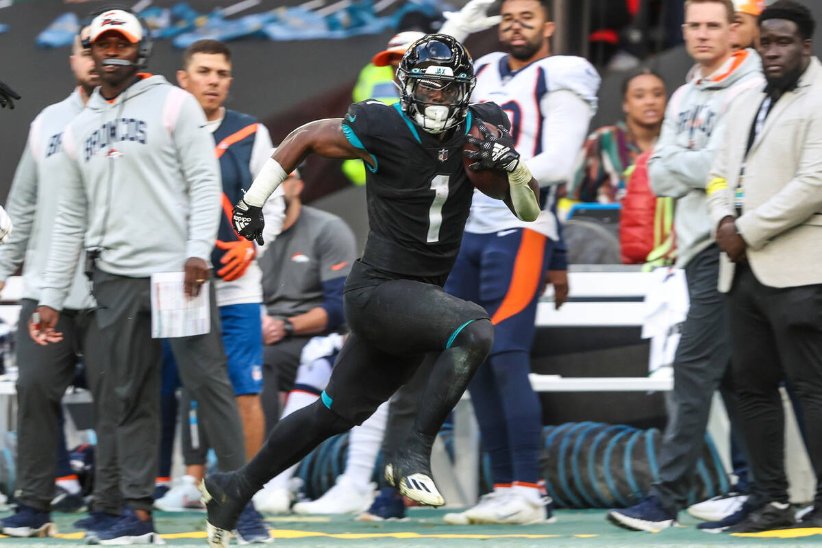 Jacksonville Jaguars running back Travis Etienne Jr. (1) runs the ball during an NFL football g ...