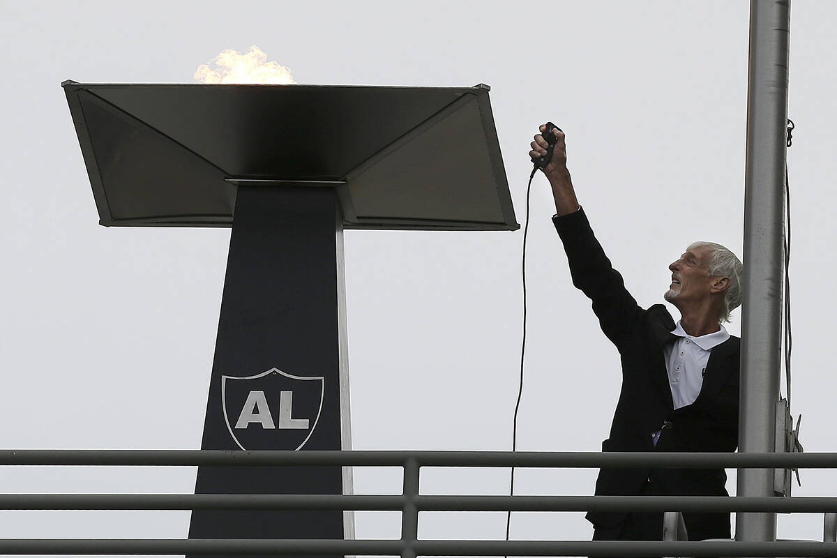 Former Oakland Raiders punter Ray Guy lights a ceremonial flame for former owner Al Davis befor ...