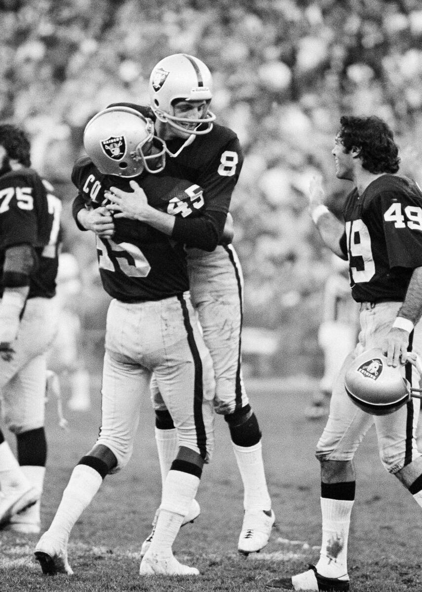 FILE - In this Dec. 28, 1975, file photo, Oakland Raiders kicker Ray Guy (8) is hugged by team ...