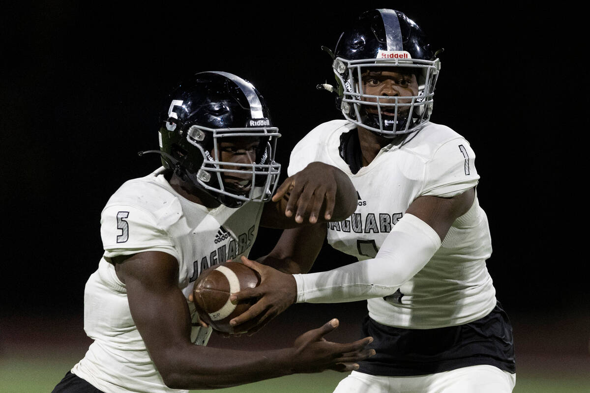 Desert Pines’ quarterback Marquis Roby (1) passes the ball off to Gregory Burrell (5) du ...