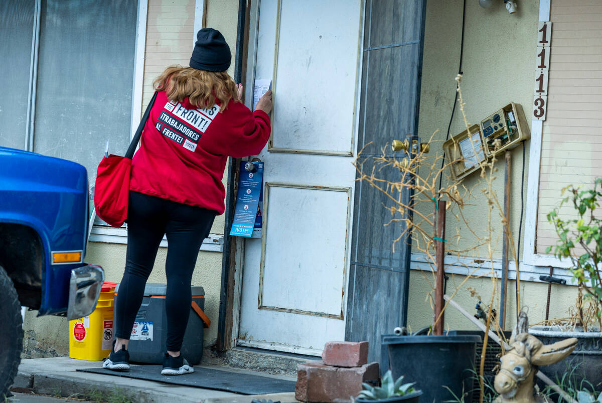 Mirian Cervantes with the Culinary Union, places voter literature on a front door during canvas ...