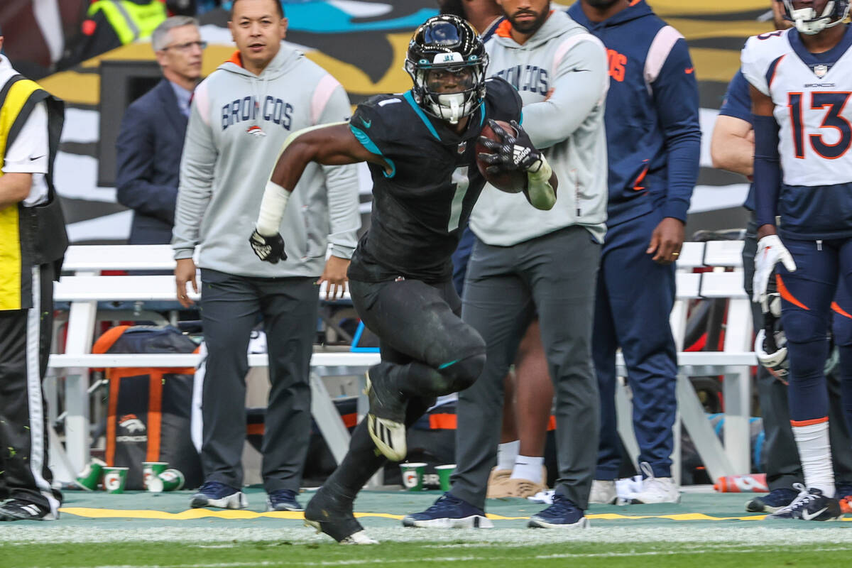 Jacksonville Jaguars running back Travis Etienne Jr. (1) runs the ball during an NFL football g ...