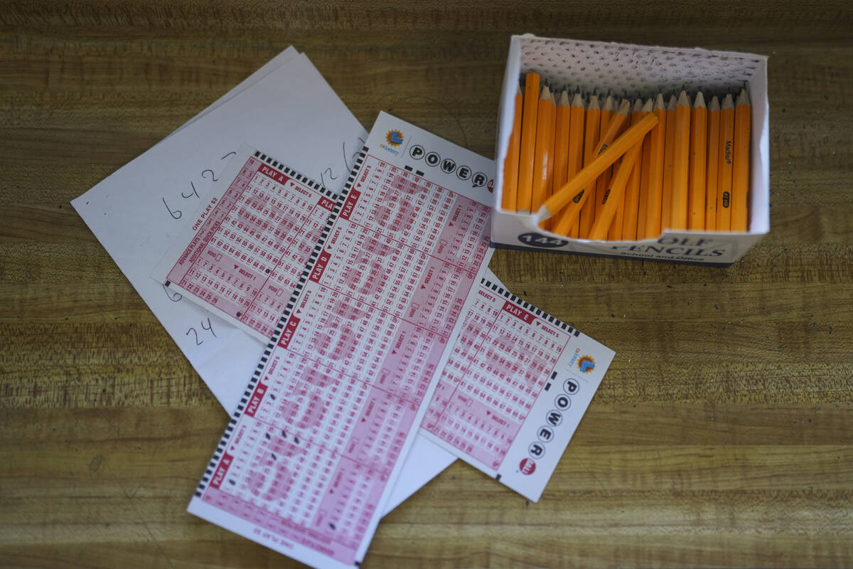Two Powerball playslips sit on top of a piece of scratch paper at Bluebird Liquor in Hawthorne, ...