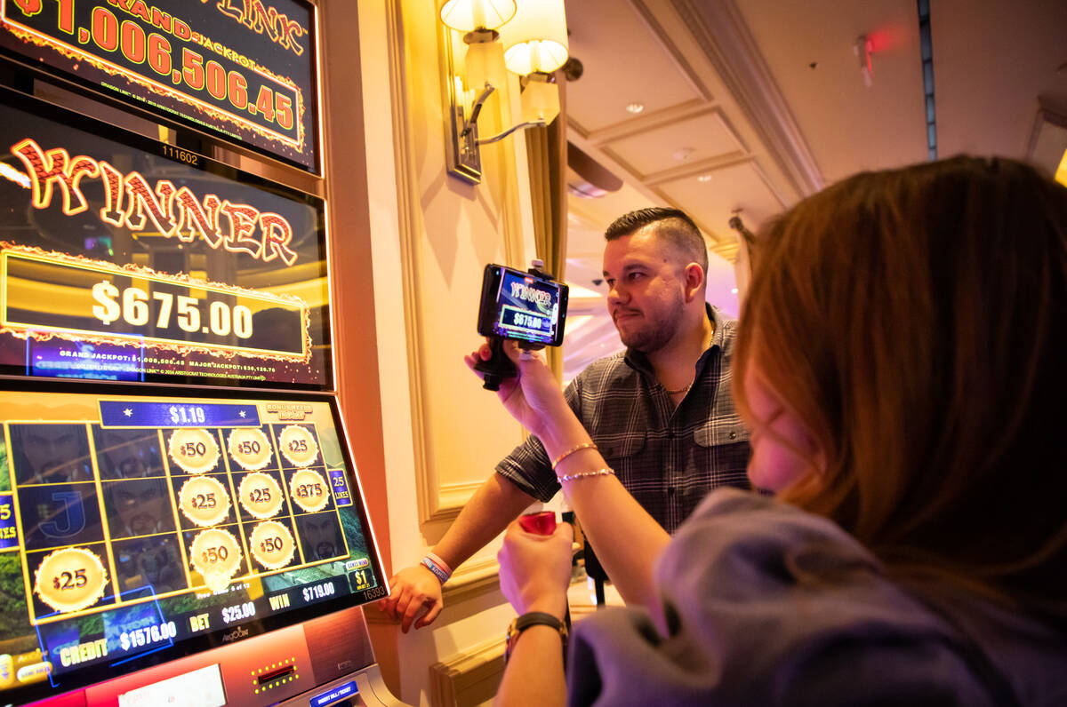 Francine Maric, right, films herself play a high limit slot as her husband, Miran Maric, watche ...