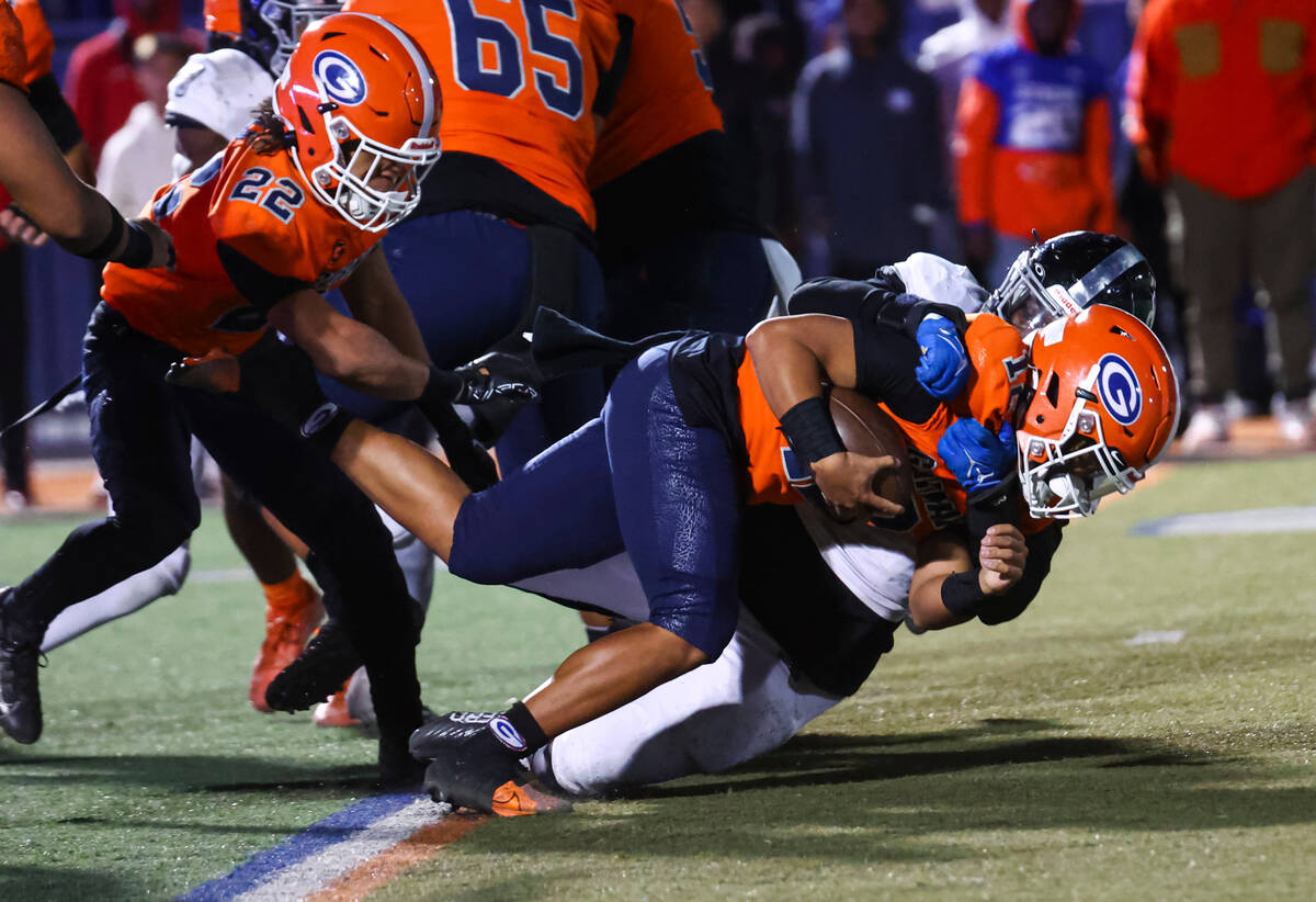 Desert Pines’ Labarrio Mays (8) tackles Bishop Gorman quarterback Micah Alejado (12) dur ...