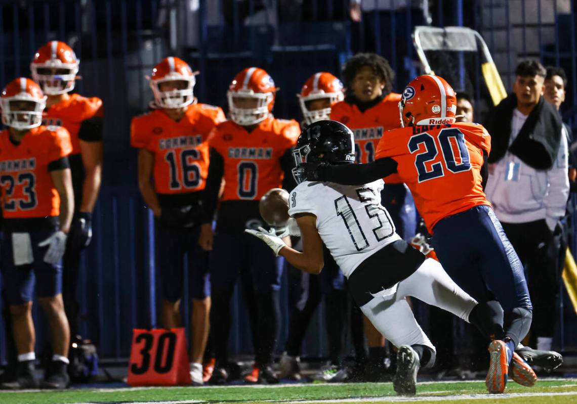 Desert Pines Izley Manutai (13) makes the catch under pressure from Bishop Gorman Kayleb Ervin ...