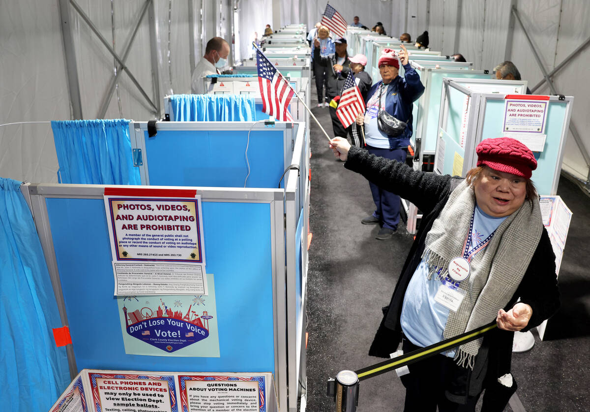 Marissa Mendoza directs a voter to an open voting machine as voters cast their ballots in an ev ...