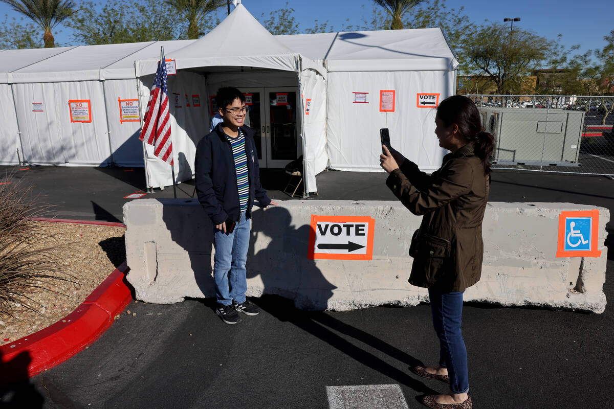 First time voter Shanden V., who only gave his last initial, poses for his mother who declined ...