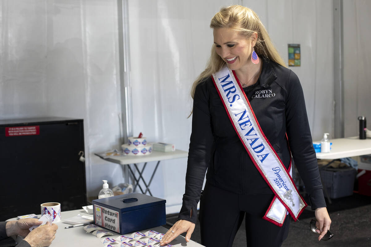 Robyn Calarco, Mrs. Nevada American 2022, takes an I Voted sticker after casting her ballot on ...
