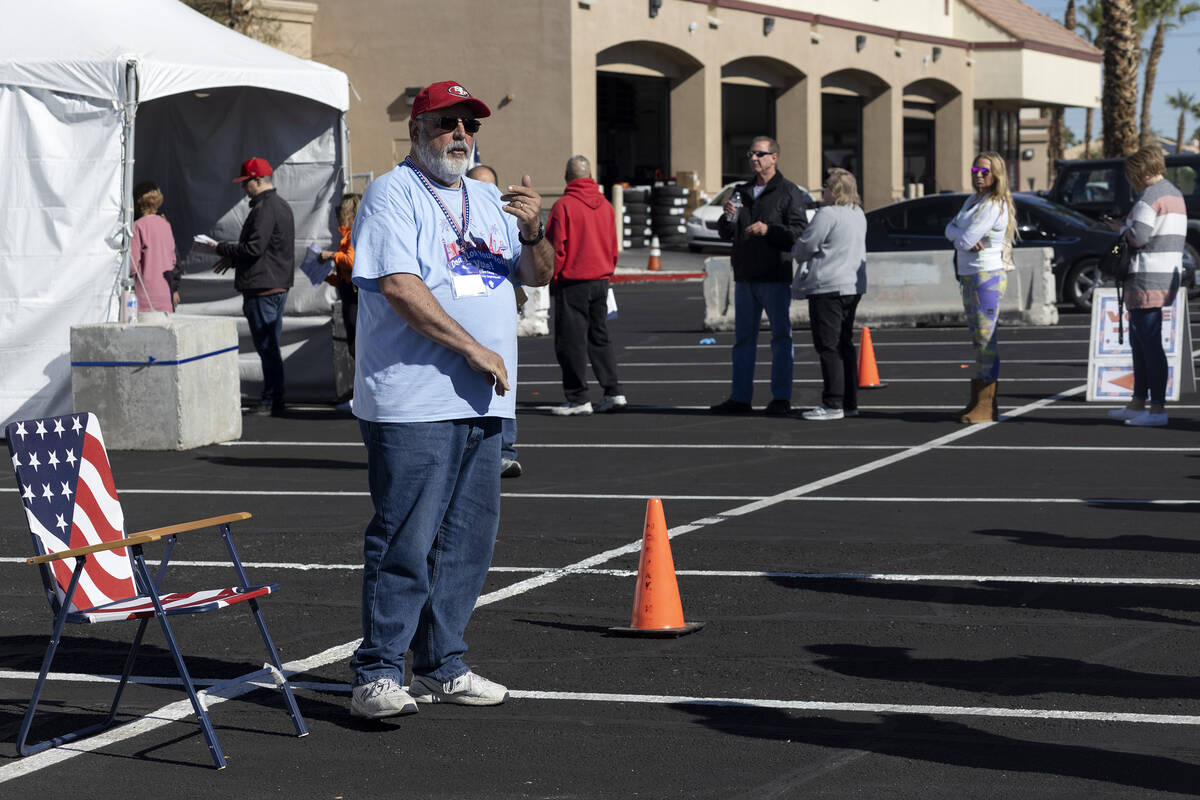 John Smith, a first-time election volunteer, directs voters on the last day of early voting, Fr ...