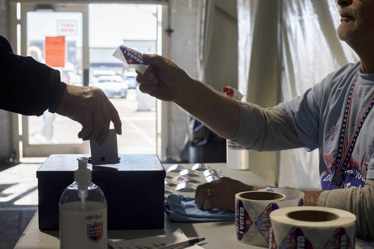 Volunteer Dennis Kepper hands out I Voted stickers on the last day of early voting as a voter d ...