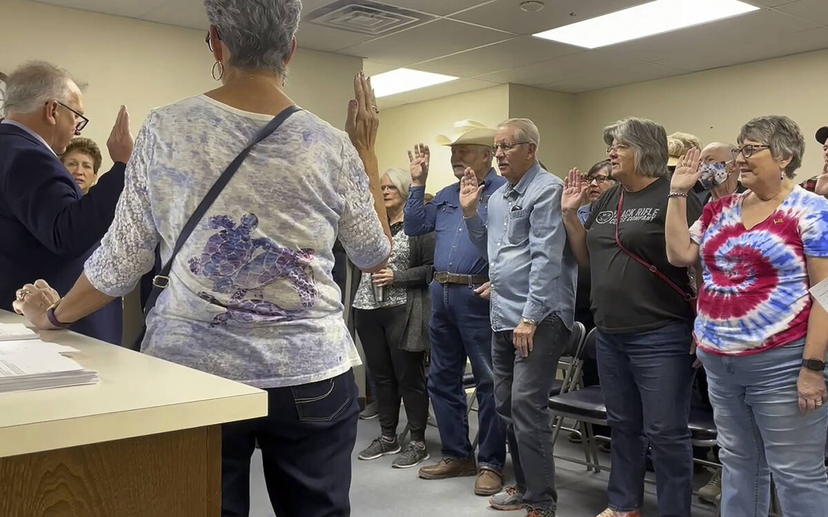 FILE - In this image from video, Nye County Clerk Mark Kampf, far left, in suit, swears in a gr ...