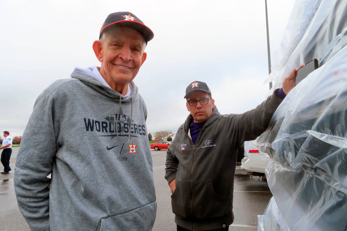 Jim "Mattress Mack" McIngvale, of Houston, left, stands near a stack of mattresses he ...