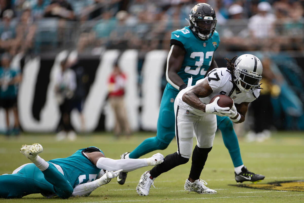 Raiders wide receiver Davante Adams (17) makes a catch and escapes Jacksonville Jaguars linebac ...