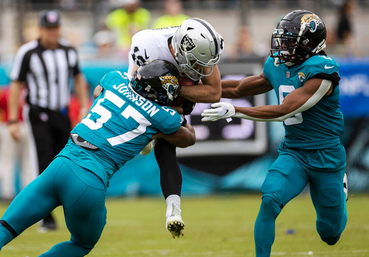 Raiders wide receiver Hunter Renfrow (13) is stopped by Jacksonville Jaguars linebacker Caleb J ...