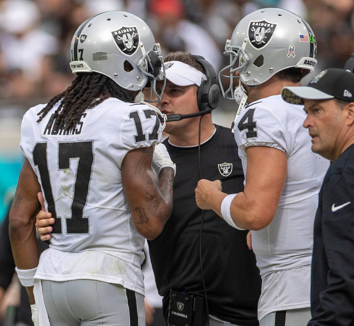 Raiders head coach Josh McDaniels speaks to wide receiver Davante Adams (17) on the sideline as ...