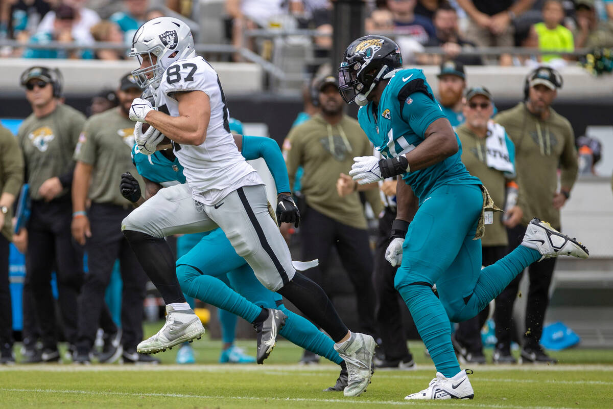 Raiders tight end Foster Moreau (87) runs down the sideline with Jacksonville Jaguars linebacke ...