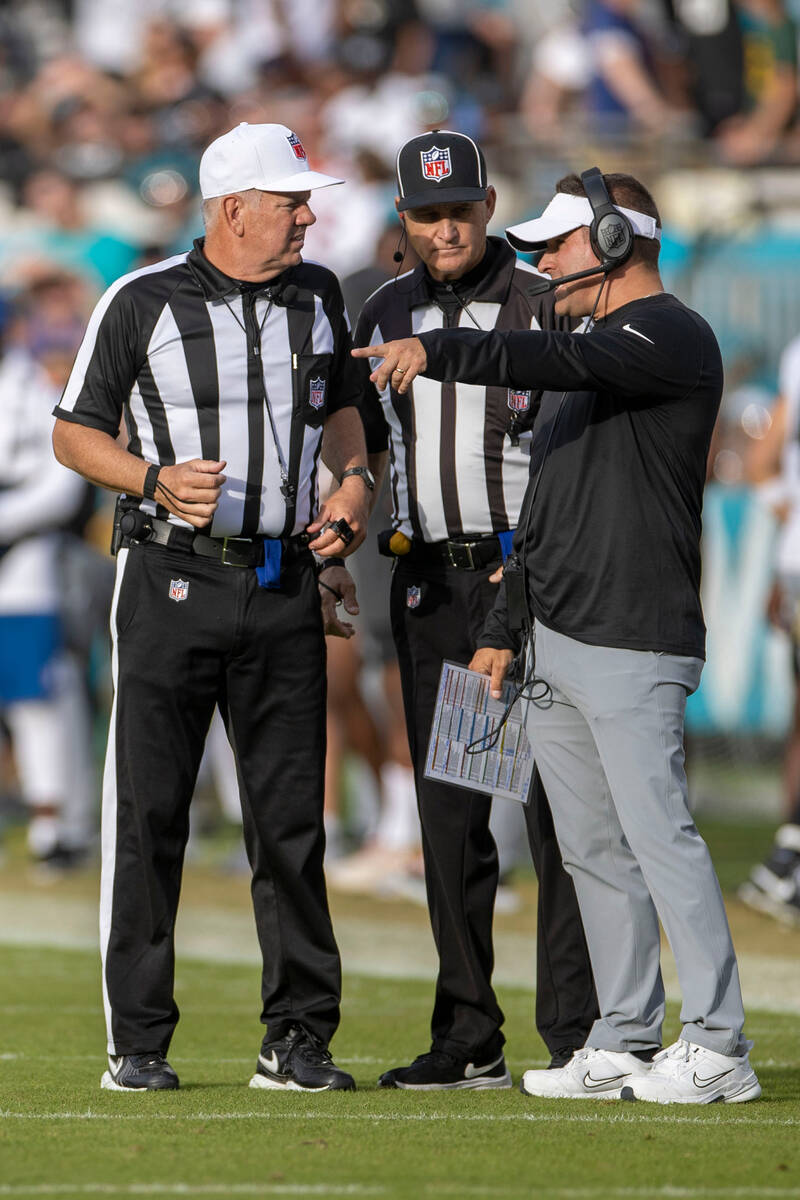 Raiders head coach Josh McDaniels speaks to referees after a flag was thrown during the second ...