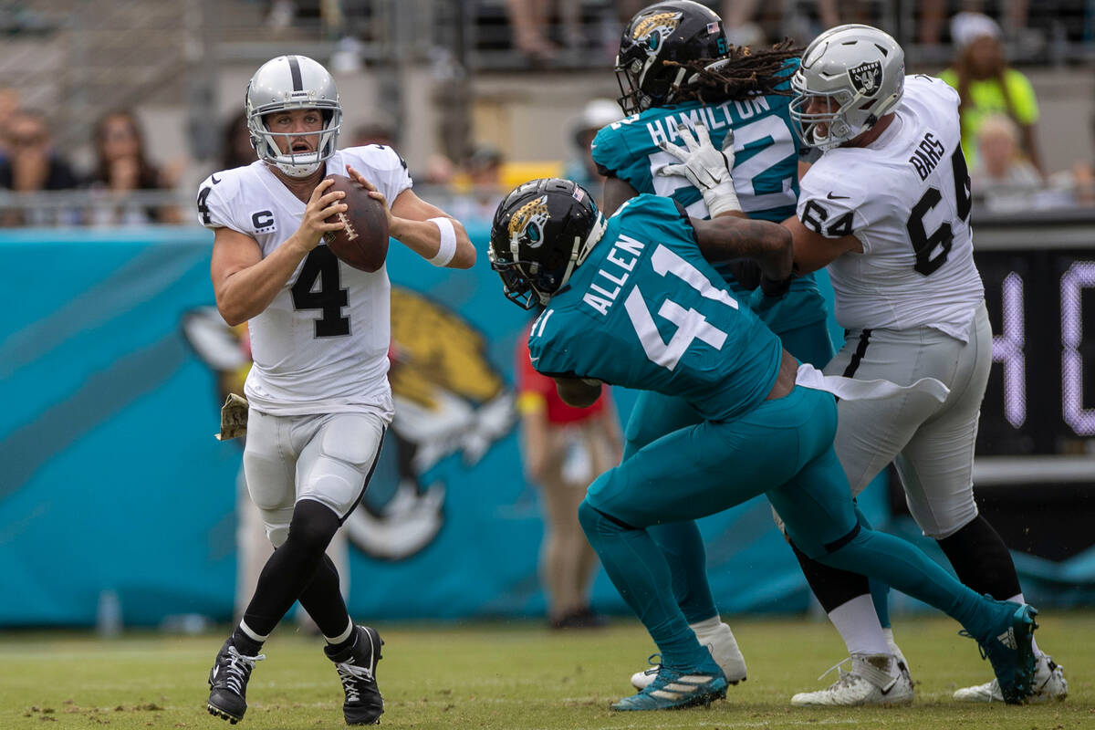 Raiders quarterback Derek Carr (4) looks to escape pressure from Jacksonville Jaguars linebacke ...