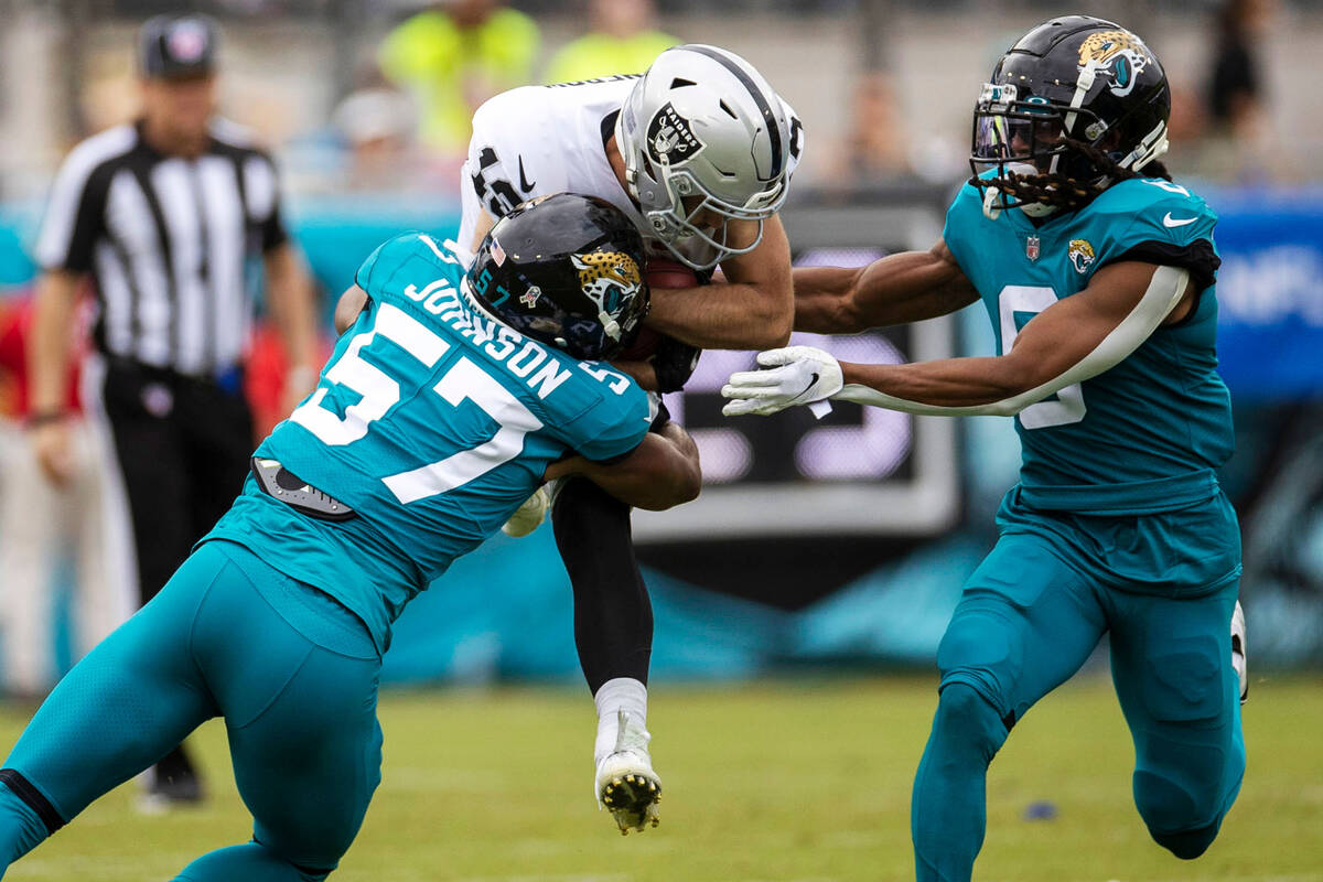 Raiders wide receiver Hunter Renfrow (13) is stopped by Jacksonville Jaguars linebacker Caleb J ...