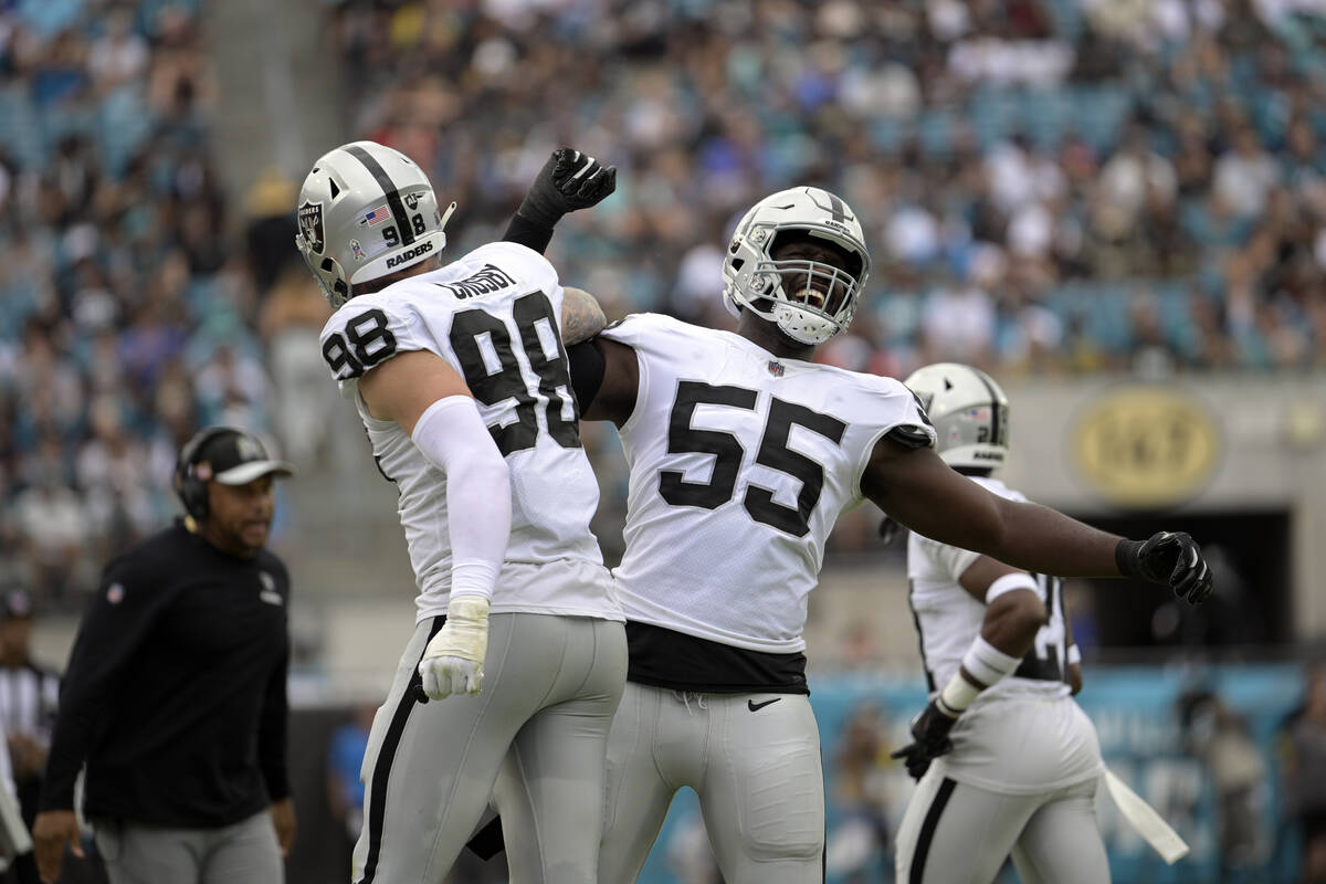 Las Vegas Raiders defensive ends Maxx Crosby (98) and Chandler Jones (55) celebrate after a pla ...