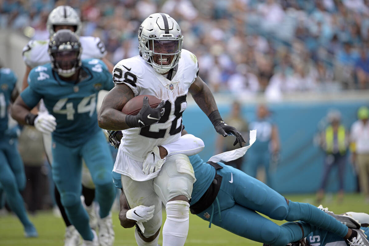 Las Vegas Raiders running back Josh Jacobs (28) is stopped by Jacksonville Jaguars cornerback T ...