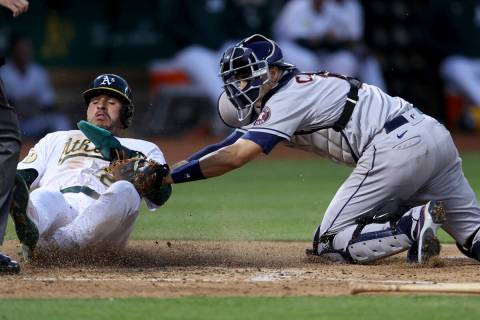 Oakland Athletics' Ramon Laureano, left, is tagged out by Houston Astros catcher Jason Castro, ...