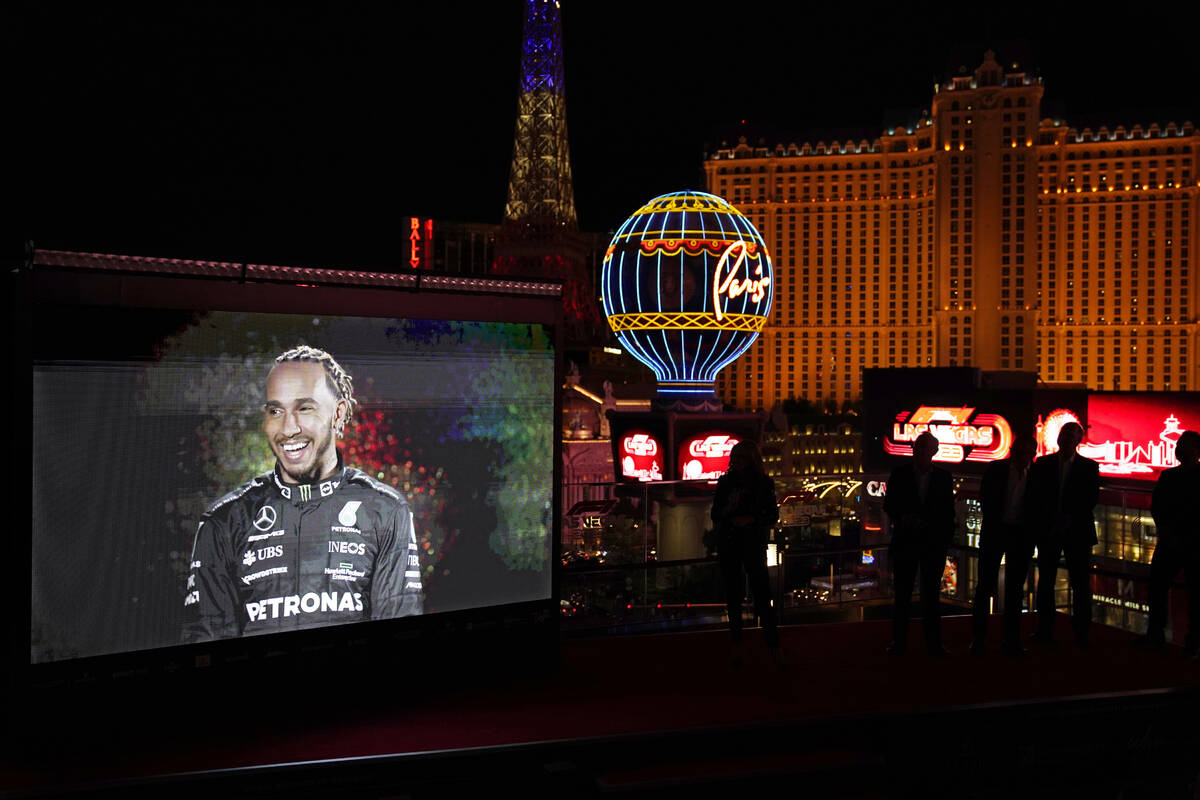 People watch as a recording of Mercedes driver Lewis Hamilton, of Britain, is projected onto a ...