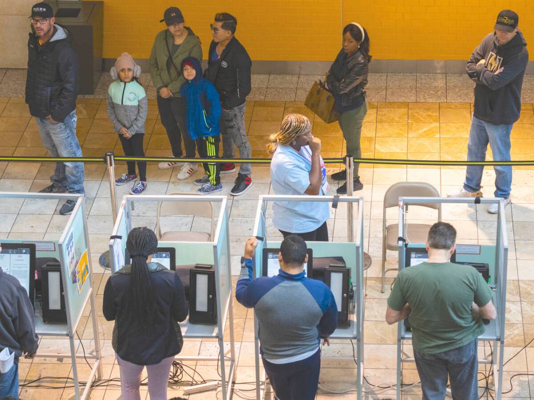 Voters cast their vote as others wait in line to cast their vote at Galleria at Sunset, on Tues ...