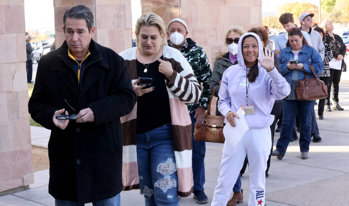 Voters, including Gainer Seliminska of Las Vegas, waving, line up to cast their ballots on Elec ...