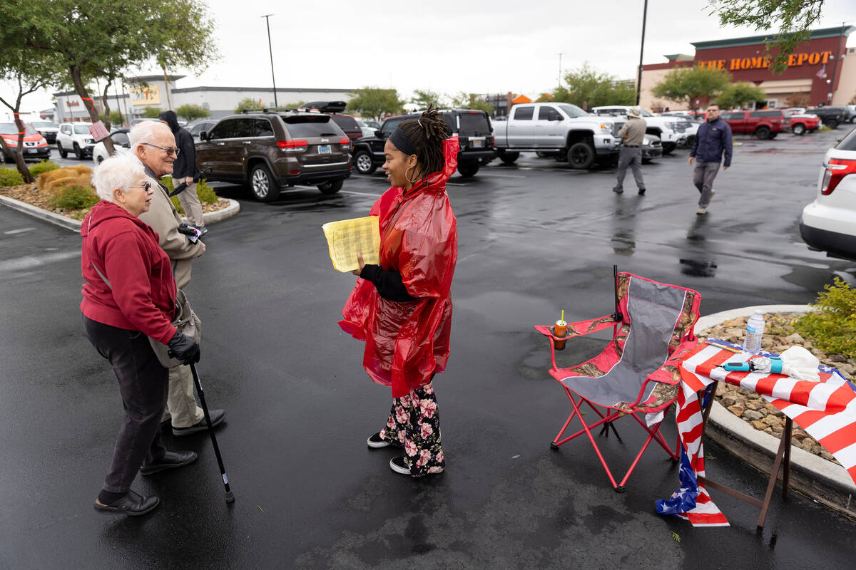Exit poll worker Brittany Johnson, center, speaks to people leaving after voting at the Centenn ...