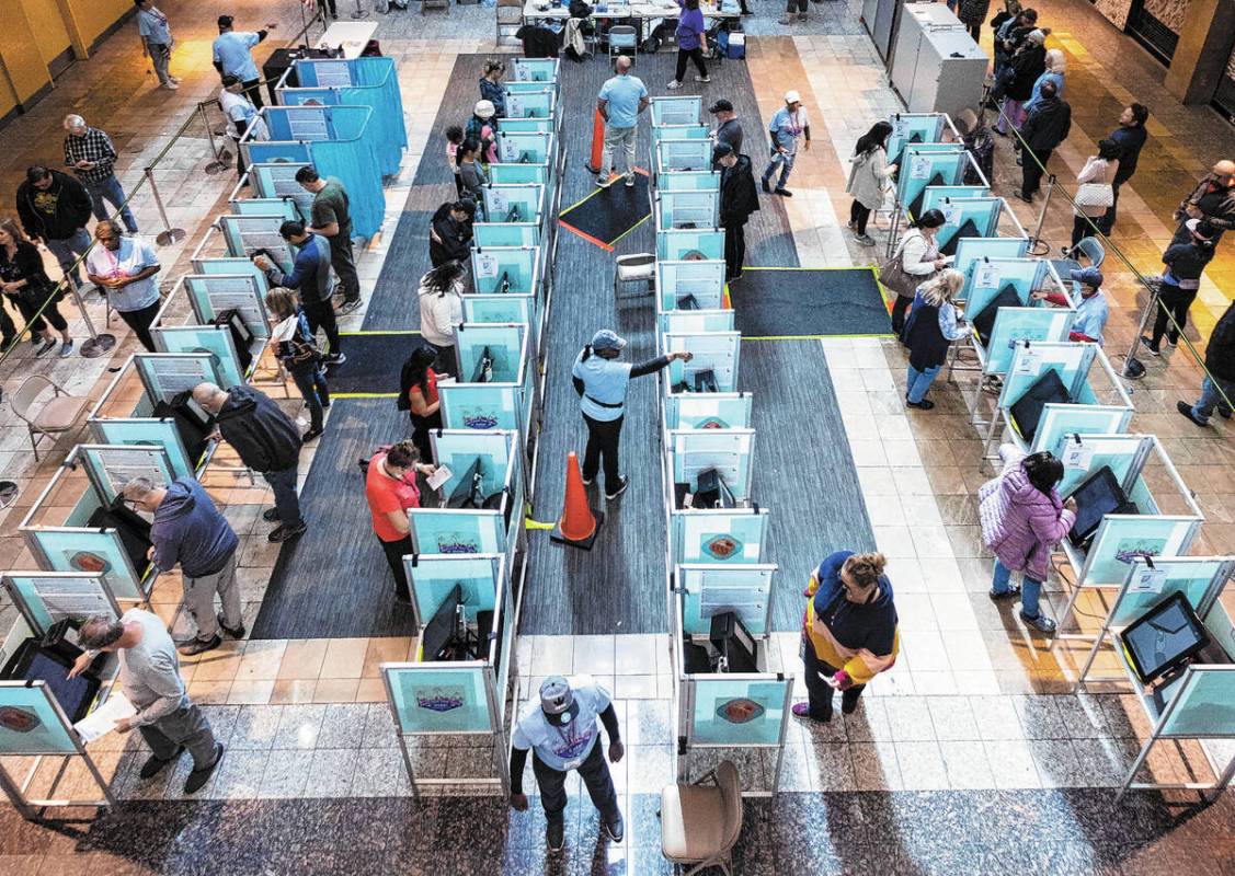 Voters cast their vote as others wait in line to cast their vote at Galleria at Sunset, on Tues ...