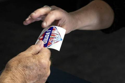 A voter accepts an I Voted Sticker on the last day of early voting, Friday, Nov. 4, 2022, at Si ...