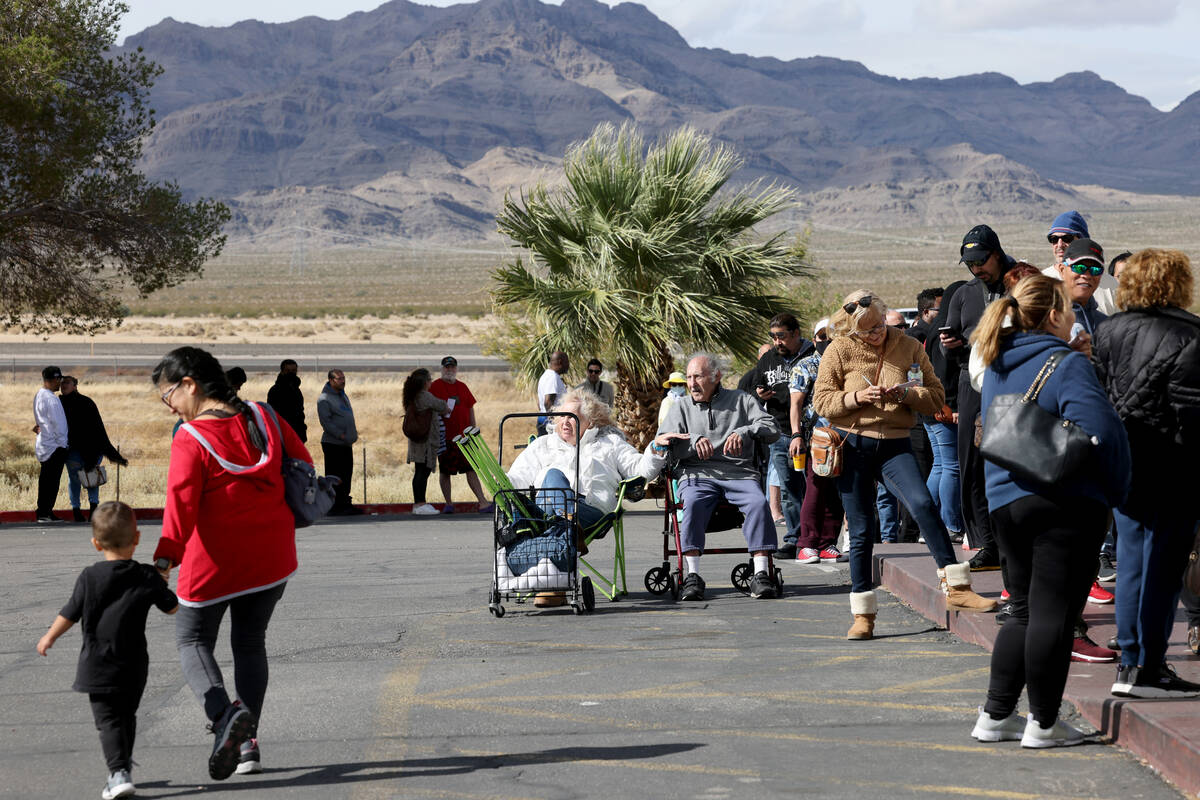 People, including Kathryn Newman and her uncle Zeev Amzalem of Las Vegas, seated, wait in line ...