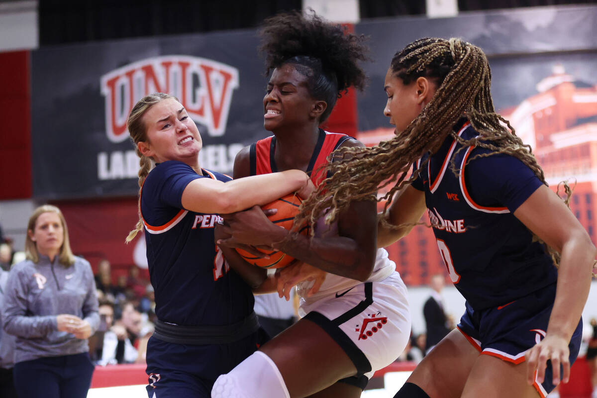 UNLV's Desi-Rae Young (23) fights for the ball against Pepperdine's Marly Walls (12) and Theres ...