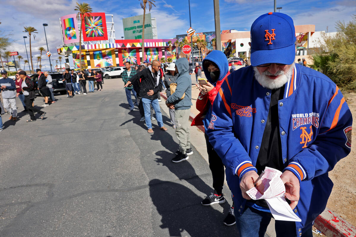 People, including Bill Tousius of Las Vegas, right, wait in line to buy lottery tickets at the ...