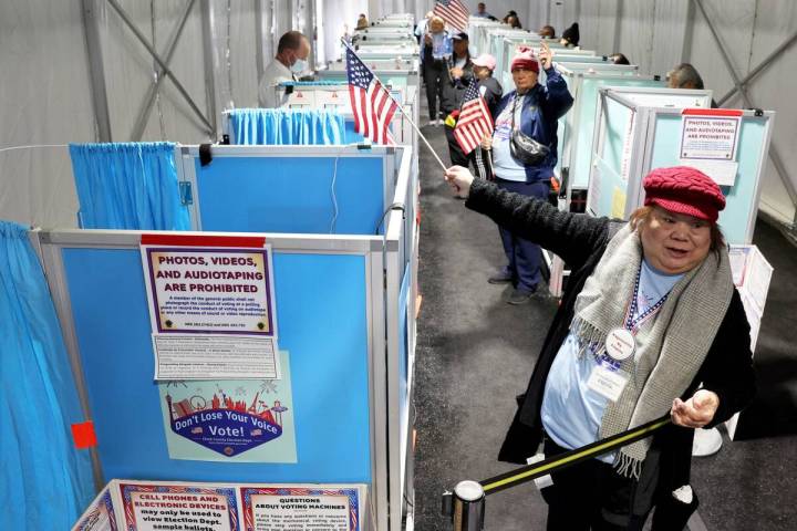 Marissa Mendoza directs a voter to an open voting machine as voters cast their ballots in an ev ...