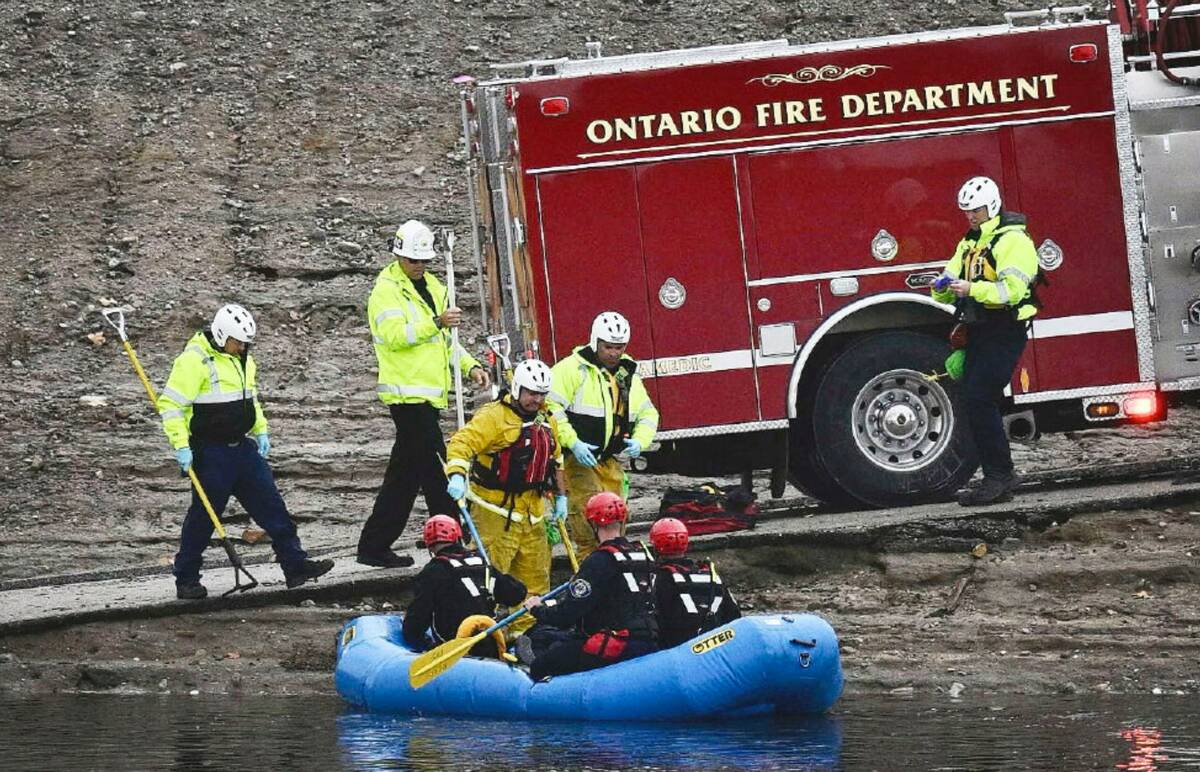 A swift water rescue team from the Ontario Fire Dept. rides in a raft on flood waters in a floo ...