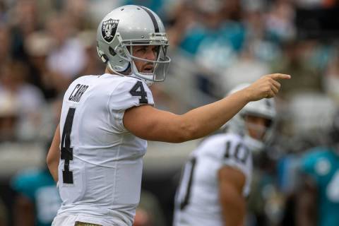 Raiders quarterback Derek Carr (4) sets up at the line of scrimmage during the first half of an ...