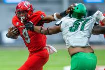 UNLV Rebels running back Aidan Robbins (9) pushes off a tackle attempt by North Texas Mean Gree ...