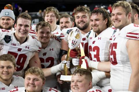 The Wisconsin Badgers pose for photos with their Las Vegas Bowl NCAA college football game trop ...