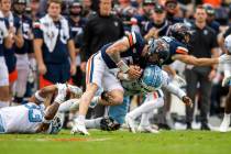 Virginia quarterback Brennan Armstrong (5) fights for extra yards as he's brought down by North ...